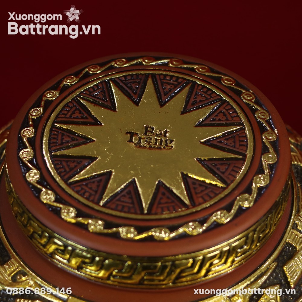 Nắp chum ngâm rượu gốm Bát Tràng dát vàng họa tiết Đông Sơn Âu Lạc, nổi bật chữ 'Bát Tràng' ở trung tâm ngôi sao vàng trên nền nâu đỏ sang trọng.