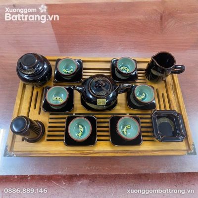 Bộ ấm trà men hỏa biến gốm sứ Bát Tràng của nghệ nhân Tô Thanh Sơn được bày trên khay gỗ. Bộ sản phẩm gồm một ấm trà dáng quả hồng màu đen với họa tiết vệt vàng, sáu chén trà lòng men xanh ngọc có hình cá koi nổi, sáu dĩa lót chén màu đen, một tống trà, một hũ đựng trà và một dĩa nhỏ hình vuông màu đen.